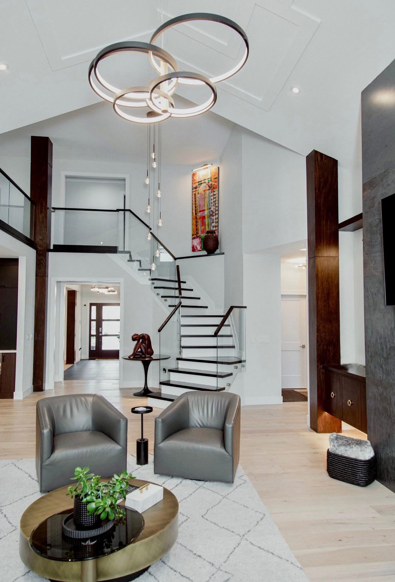 Dramatic two-story foyer with sculptural ring chandelier and floating staircase