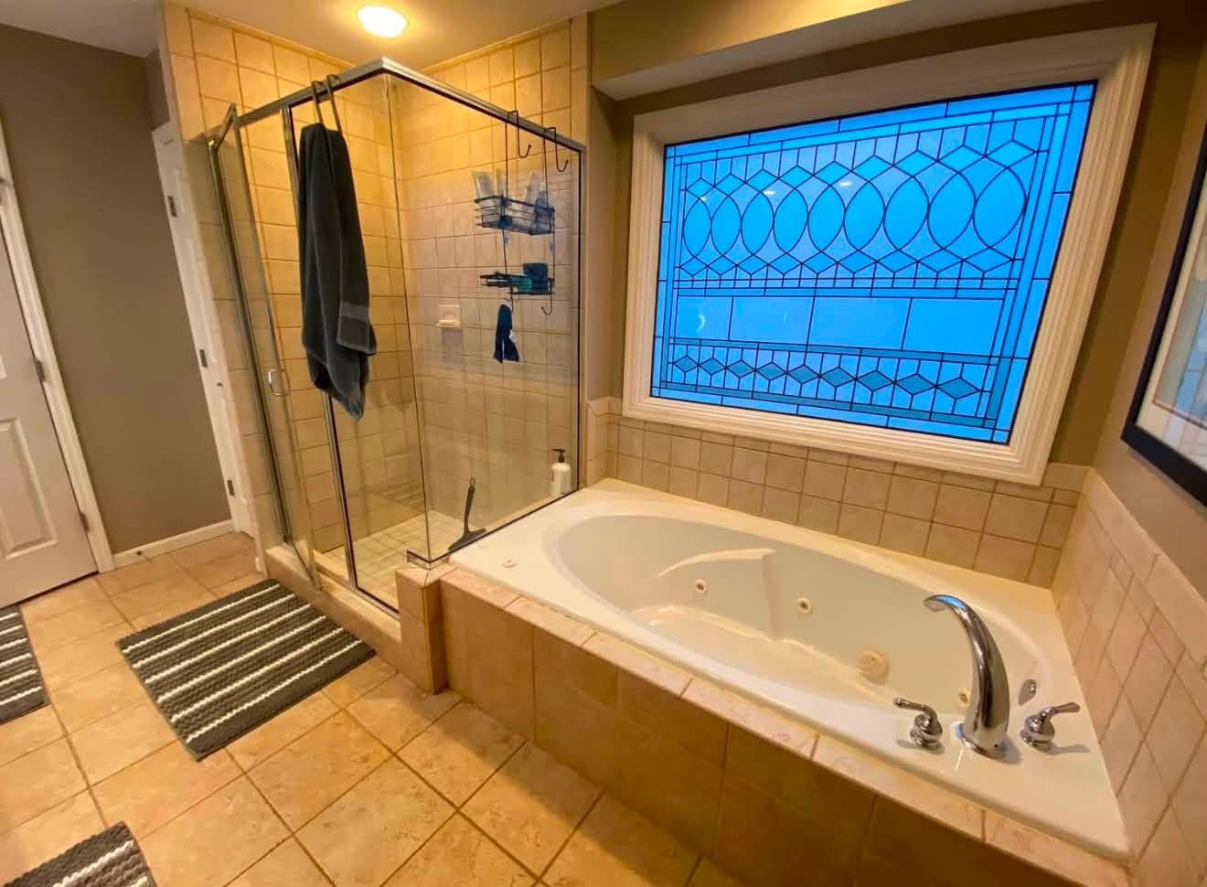 Before: corner shower and jetted tub with stained glass window